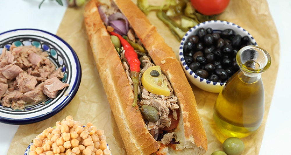 Tunisian kaskrout lablabi, a popular street food sandwich made with chickpeas, harissa, olive oil, tuna, and egg. A true taste of Tunisia’s culinary heritage.