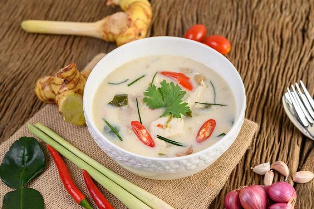 Tom Kha is a Thai coconut milk soup adapted for halal diets using halal chicken and fish sauce alternatives. Its base includes coconut milk, lemongrass, galangal, lime leaves, mushrooms, and chili.